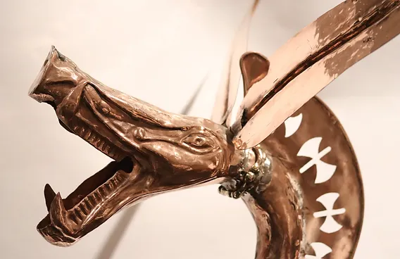 Carnyx en cuivre martelé, repoussé avec ajours en forme de haches