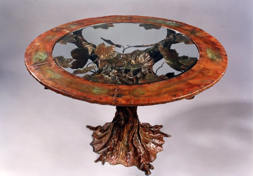 Grand Guéridon en cuivre patiné au feu. Armature en acier, verre 12mm